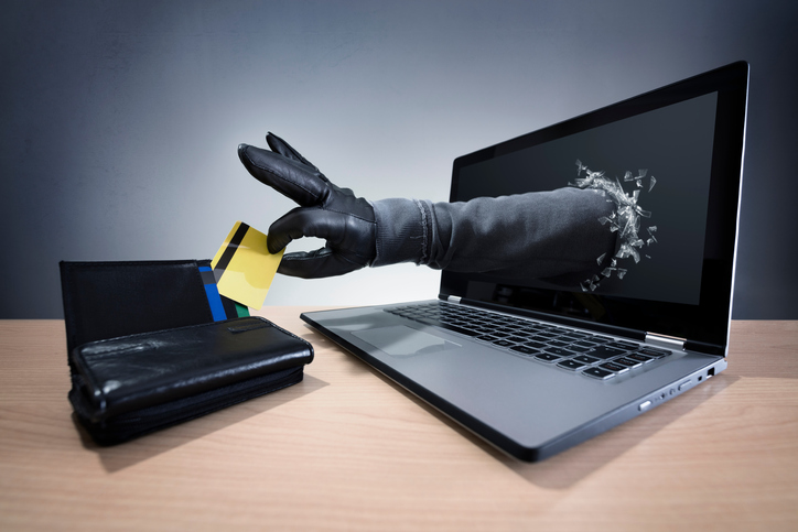 Stealing a credit card through a laptop concept for computer hacker, fraud, network security and electronic banking security